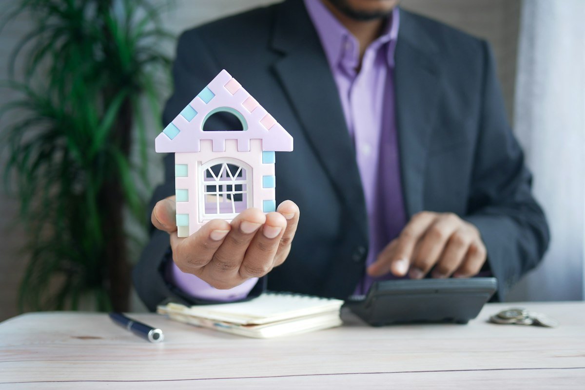 Tính chi phí mua nhà Vinhomes Hóc Môn: mô hình nhà và máy tính trên bàn