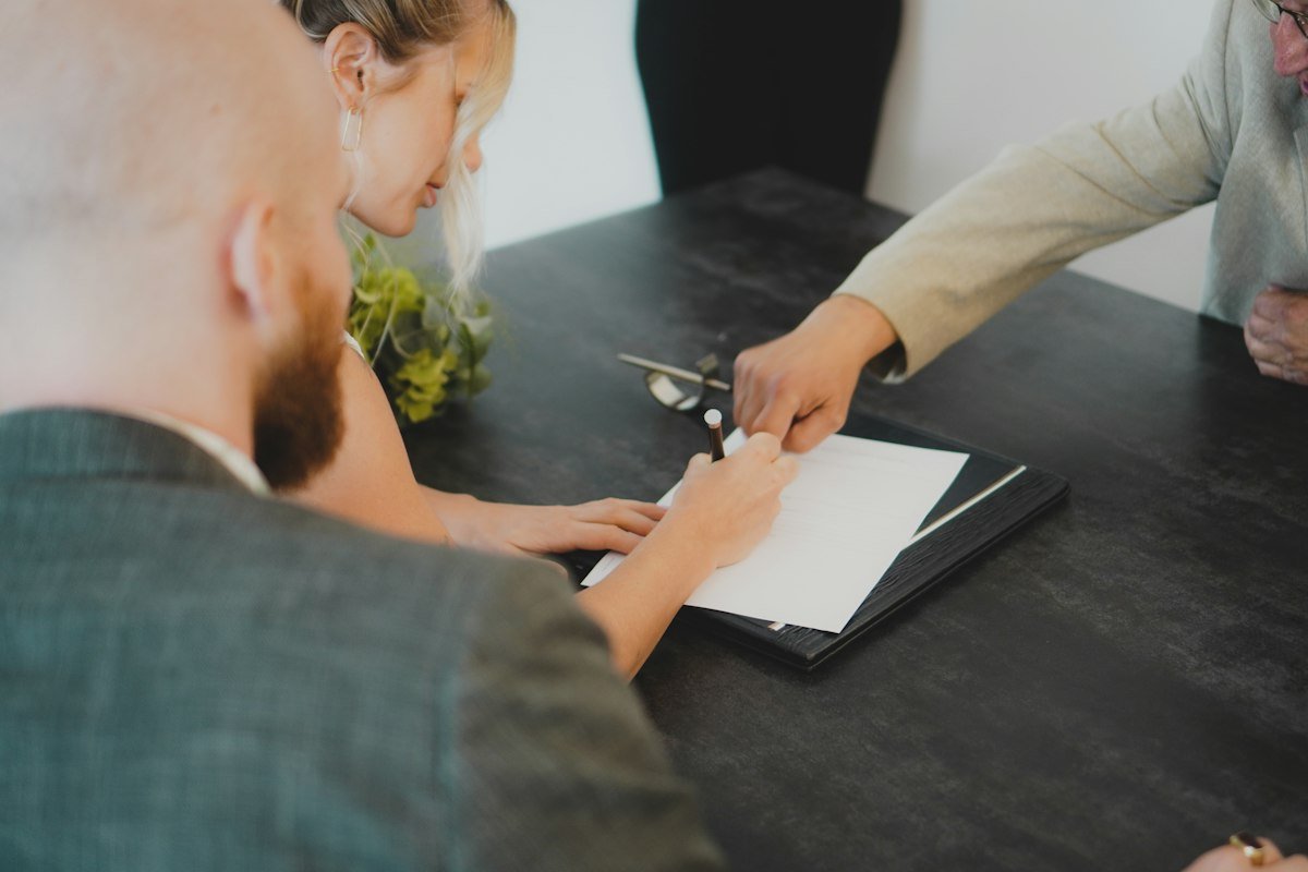 Thủ tục mua nhà Vinhomes Hóc Môn: hai vợ chồng ký hợp đồng tại bàn làm việc